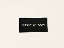 Load image into Gallery viewer, A black rectangular embroidered patch with the text 'CHILEY LITHGOW' in white vertical lettering, shown on a plain off-white background.